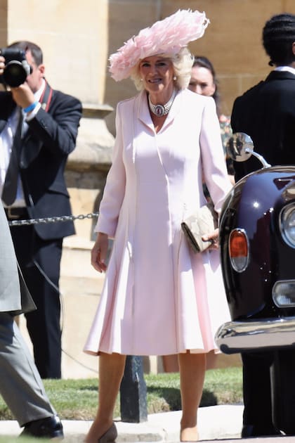 La Reina eligió el mismo vestido con que acompañó al príncipe Harry y a Meghan Markle el día de su boda, un diseño de Anna Valentine. Lo accesorizó con pulseras finas de oro, choker de cinco hileras de perlas y broche central, y tocado Philip Treacy.