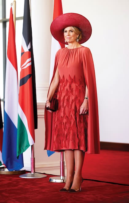 La Reina en los jardines Uhuru, con un vestido con efecto capa y falda evasé de Natan Couture que había comprado para el Día del Rey, en 2023. Completó ese look de la segunda jornada con una pamela de ala ancha de Fabienne Delvigne, stilettos modelo Plexi de Gianvito Rossi y pendientes art nouveau de la firma madrileña Luz Camino.