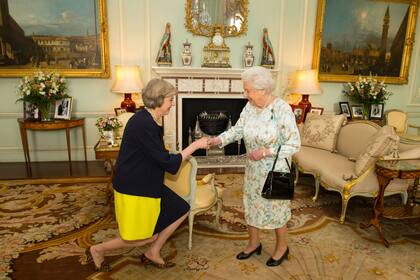 La reina Isabel II, con su infaltable cartera, recibe a Theresa May, en 2016, y le encarga formar gobierno