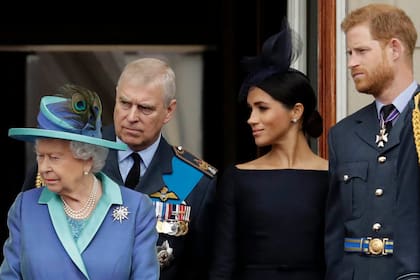 La reina Isabel II de Gran Bretaña, el príncipe Andrés, Meghan la duquesa de Sussex y el príncipe Harry se paran en un balcón para ver un avión de la Royal Air Force pasar sobre el Palacio de Buckingham en Londres, el 10 de julio de 2018