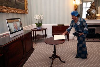 La reina Isabel II de Gran Bretaña en una pantalla durante una videollamada desde el Castillo de Windsor, donde está residiendo, en una audiencia virtual para recibir a su excelencia Sara Affoue Amani, embajadora de Costa de Marfil, en el Palacio de Buckingham, el 27 de abril de 2021. (Yui Mok/Pool via AP)