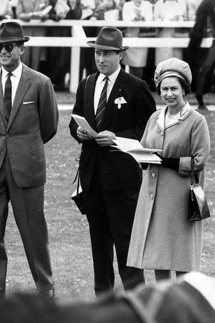 La reina Isabel II y el duque de Edimburgo (izquierda) hablando con el director de carreras Lord Porchester, o Henry Herbert, en Newbury Races, Inglaterra, el 30 de septiembre de 1969