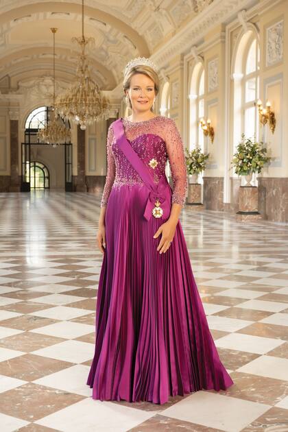 La Reina lució la Tiara de las Nueve Provincias, en la que se representan con once diamantes las nueve provincias belgas, Bruselas y el Congo, su antigua colonia. Lo combinó con un vestido de Armani en tono morado y pendientes de diamantes estilo art déco.