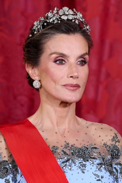 La Reina se coronó con la tiara Floral, una pieza con más de un siglo de historia. Esta joya fue el regalo que el gobierno español hizo a su suegra, la reina Sofía, con motivo de su casamiento con Juan Carlos I, en 1962. Confeccionada en platino y diamantes, su estructura permite que las tres flores principales se desmonten, brindando la posibilidad de lucirlas también como broches independientes o adaptadas como
gargantilla. Le sumó pendientes con brillantes.