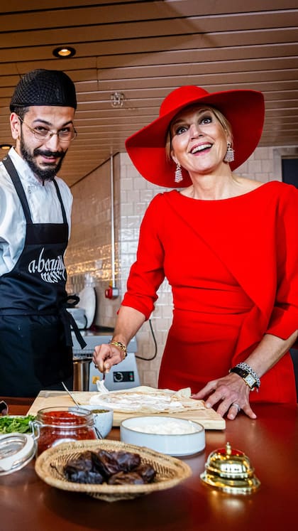 La reina se puso manos a la obra y colaboró en el armado de los platos