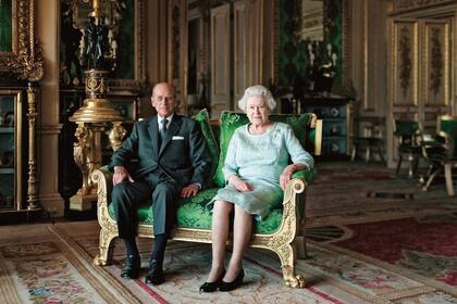 La Reina y el duque de Edimburgo posan en el Salón Verde de Windsor para un retrato oficial. La imagen fue encargada por la Galería Nacional de Retratos para conmemorar el 90o cumpleaños del príncipe Felipe, así como el Jubileo de Diamante de la Reina