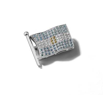 La réplica del broche de Eva Perón, por Testorelli para el Bicentenario. La idolatrada es de oro blanco 18k, tiene topacios azules Sky, citrinos en el sol y diamantes blancos.