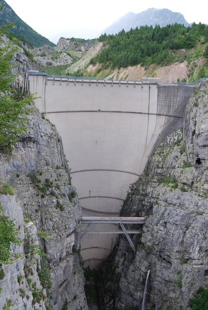 La represa de Vajont en la actualidad. El monte con pinos que se ve atrás a la derecha son los restos del derrumbe. En ese lugar estaba en 1963 el lago del que surgió una ola de 200 metros de altura por encima del dique