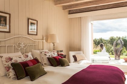 La ropa de cama mantiene los colores de la casa, verde y bordó