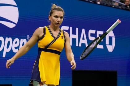 La rumana Simona Halep lanza molesta su raqueta durante un partido contra la ucraniana Elina Svitolina, en la cuarta ronda del Abierto de Estados Unidos, en Nueva York, el domingo 5 de septiembre de 2021. (AP Foto/Seth Wenig)