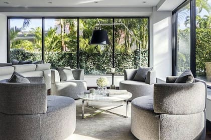La sala de estar cuenta con un apartado con sillones y una pequeña mesa de vidrio