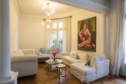 La sala de estar que da al jardín y que es el punto de reunión. Tanto los sillones como la mesa baja con tapa de mármol son de Anthropologie, de Nueva York. Los compró cuando se instaló con su familia en Manhattan y los trajo al regresar a Buenos Aires. Sobre la pared, una obra de Nicolás García Uriburu.