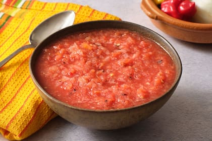 La salsa de tomate cumple un rol fundamental en el armado de una pizza
