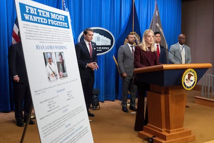 La secretaria de Justicia Pam Bondi junto a un cartel con la información del prófugo canadiense Ryan James Wedding