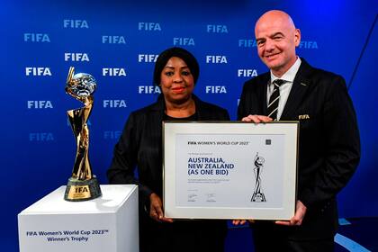 La secretaria general de la FIFA, Fatma Samoura (izq.) Y el presidente de la FIFA, Gianni Infantino, posan junto al Trofeo de la Copa Mundial Femenina después del anuncio de que Australia / Nueva Zelanda son los anfitriones ganadores de la Copa Mundial Femenina de la FIFA 2023