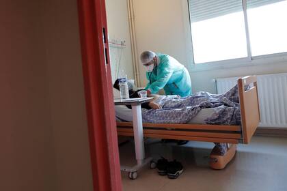 Un médico con máscara y traje de protección, trabaja en una unidad de medicina en el hospital privado Clinique de lEstree - ELSAN en Stain dónde atiende pacientes con coronavirus