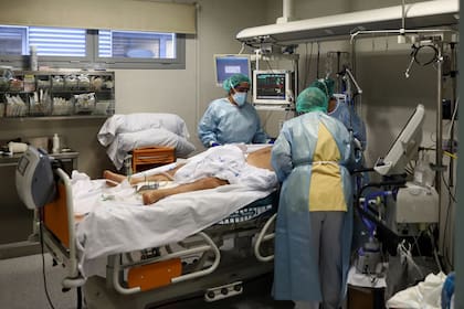 Trabajadores médicos atienden a un paciente infectado por COVID-19 en la unidad de cuidados intensivos (UCI) del Hospital Universitario Infanta Sofía, en Madrid, España