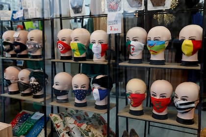 Máscaras protectoras con diseños de banderas se exhiben en una tienda en París