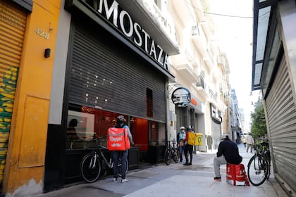 La situación de los comercios en la Avenida Corrientes. Gran parte de los locales cerrados y algunos optaron por el delivery