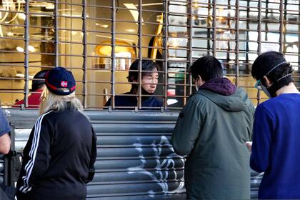 La situación en la zona comercial de Cabildo y Juramento. Algunas personas en la calle y atención con persianas bajas