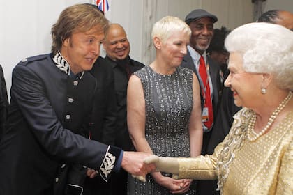 La soberana saluda a Paul Mc Cartney –detrás se ve a Annie Lennox– después del concierto por el 60° aniversario de su ascensión al trono. En 1965, la Reina había distinguido a The Beatles como Miembros de la Orden del Imperio Británico.