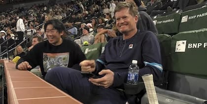 La sonrisa del coach de Watanuki, el extenista sudafricano Wayne Ferreira, viendo cómo su pupilo tomaba una gaseosa en medio del partido con Tiafoe