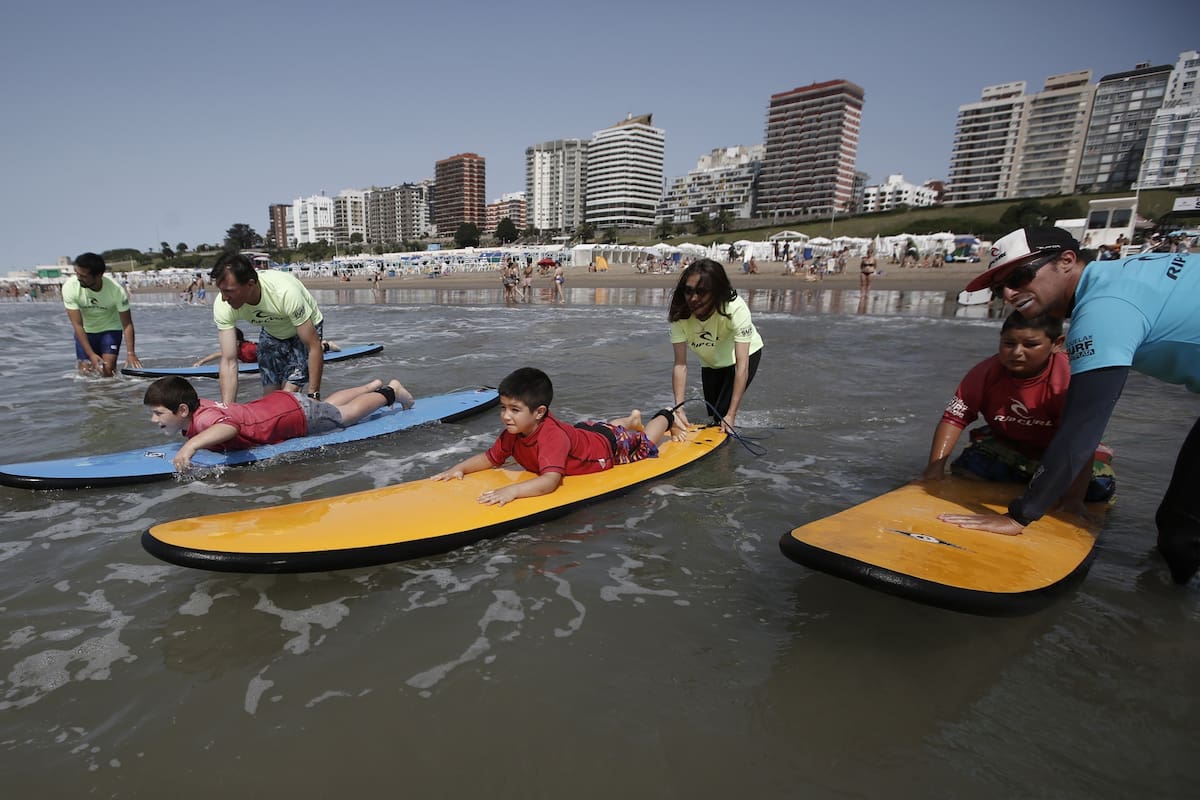 La sostiene el campeón argentino Maximiliano Prenski, junto a ONG y colaboradores; los alumnos se suben a una tabla por primera vez y, para algunos de ellos, también es el debut en la playa