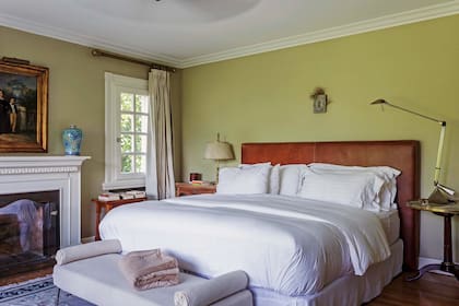 La suite principal, con el lujo divino de su propia chimenea, tiene una cama con respaldo de cuero, banqueta a sus pies y otra contra el ventanal (todo del Estudio). A la mesa de luz junto a la ventana, la mandaron a lavar y le pusieron tapa de cuero.