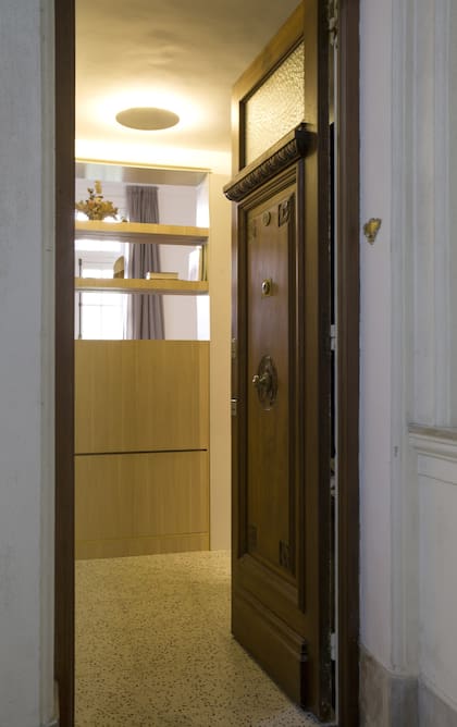 La tapa abatible del mueble a medida que se ve no bien se abre la puerta esconde un zapatero.