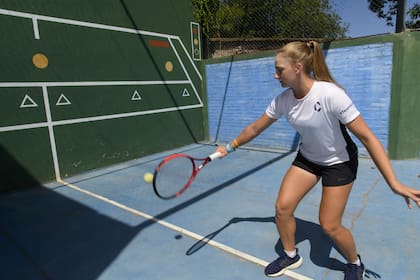 La tenista Luna Cinalli, de 15 años y top 30 mundial en la categoría junior, jugando en el frontón que le hicieron sus padres en su casa, en Ricardone, Santa Fe; tiene un impecable revés de una mano