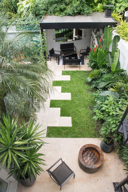 La tira verde que conecta la parrilla con el sector del fogonero es un conjunto de especies tropicales que permiten dar densidad y combinar distintos verdes: Alocacia odora, Strelitzia nicolai, Canna sp., Senecio kaempferi, Monstera deliciosa y helechos Dryopteris filix-mas
