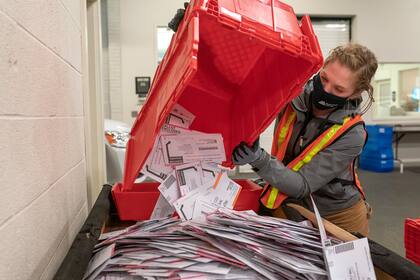 La trabajadora electoral Sarah Sladek vacía una caja de boletas enviadas por correo en la Oficina de Elecciones del Condado de Multnomah el 2 de noviembre de 2020 en Portland, Oregon