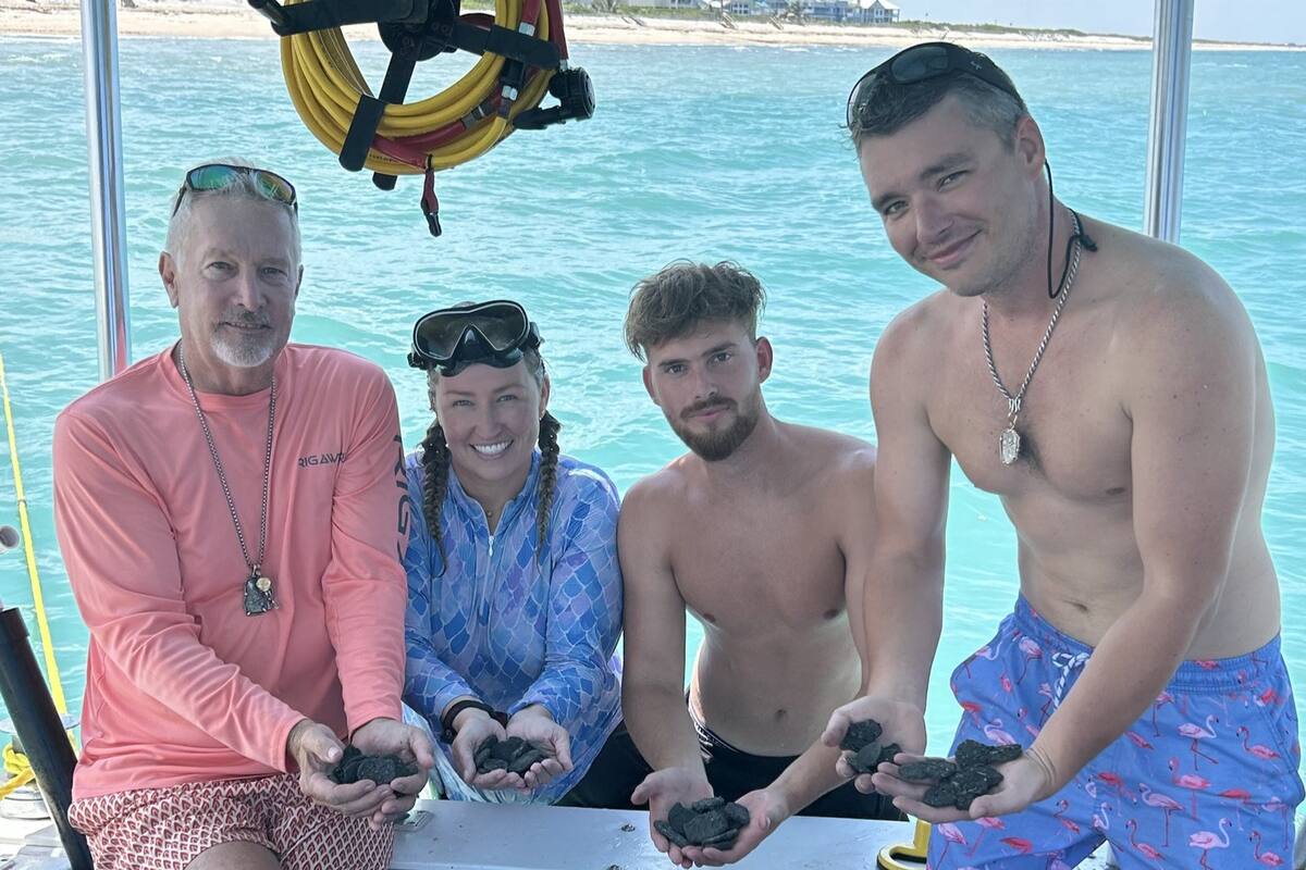 La tripulación del M/V Lilly May (C-69) junto a las monedas rescatadas