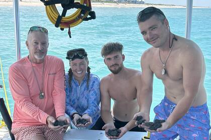 La tripulación del M/V Lilly May (C-69) junto a las monedas rescatadas