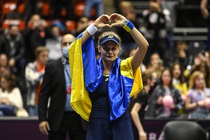 La ucraniana Dayana Yastremska, envuelta en la bandera nacional de su país, saluda al público que la alentó en el torneo de Lyon