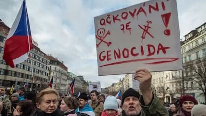 "La vacunación es genocidio", dice un cartel en una protesta contra la vacunación obligatoria en Praga el 9 de enero de 2022.