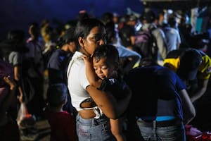 La venezolana Luisleibis Navarro espera con su hijo en brazos para subir a un barco que va desde Miramar, en la costa panameña del Caribe, a la frontera con Colombia, el 25 de febrero de 2025, mientras los migrantes regresan desde el sur de México tras renunciar a llegar a Estados Unidos en un flujo a la inversa provocado por la campaña antiinmigración del gobierno del presidente Donald Trump.