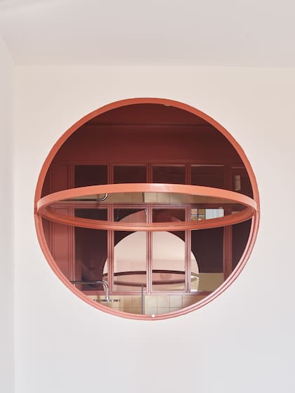 La ventana circular en el dormitorio principal permite la entrada de luz natural hacia el cuarto de baño y el vestidor familiar.