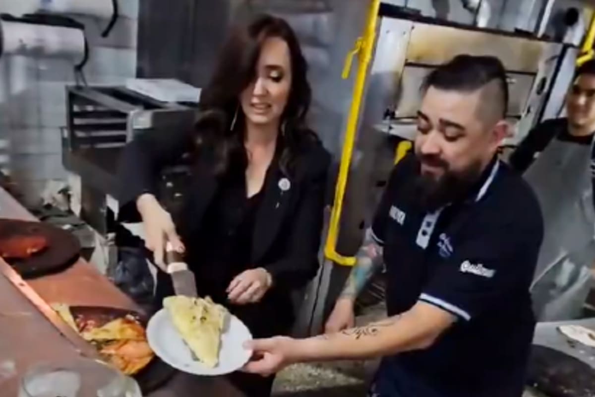 La vicepresidenta Victoria Villarruel sirve una porción de fugazzeta durante su paso por la reconocida pizzería porteña "El Cuartito"
