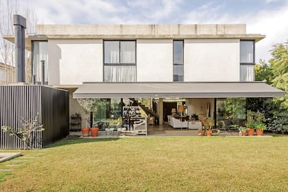 La vista del contrafrente muestra el estilo racional de la arquitectura con una planta baja libre abierta a la galería y al jardín con pileta.