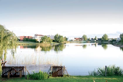 La vista desde el jardín se extiende hacia la laguna. A la izquierda asoma el sauce, bajo el cual se arman mateadas y ricas comidas a la parrilla