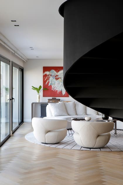 La vista hacia el living, con las espalda de los sillones curvos en buclé (Estudio Cali Herrera) y de fondo, las madonnas de la artista Adriana de Aisenberg.