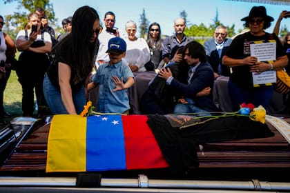 La viuda, el hijo y la hermana del militar disidente venezolano Ronald Ojeda, enterrado en el Cementerio Canaán en Santiago de Chile, el 8 de marzo de 2024, después de que fue secuestrado y sus restos encontrados debajo de concreto en las afueras de la capital.