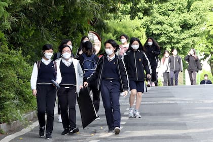 Los alumnos caminan hacia el colegio con tapabocas obligatorios