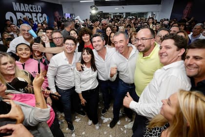 Laciar, entre los hermanos Juan José y Marcelo Orrego, en la celebración tras ganar la intendencia