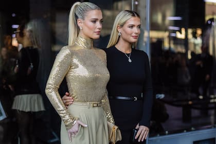 Lady Amelia, con un outfit en dorado y beige; y Eliza, full black, listas para asistir al desfile de Michael Kors, en Nueva York.