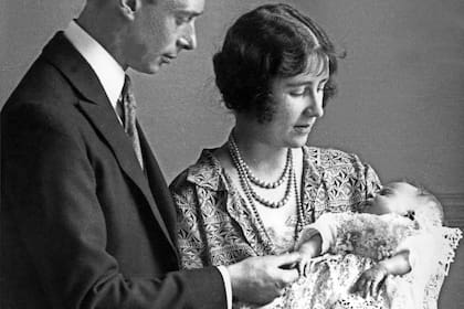Lady Elizabeth Angela Marguerite Bowes-Lyon, hija del decimocuarto conde de Strathmore, la duquesa de York y su esposo, el príncipe George, duque de York, sostienen a su hija, la princesa Isabel, futura reina de Gran Bretaña, en 1926