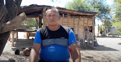 Lakín, cacique de la comunidad Misión Santa María; de fondo se ve su casa y uno de los tanques distribuidos para almacenar el agua.