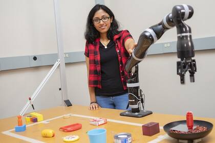 Lakshmi Nair del Georgia Tech junto al brazo robótico que puede crear nuevas herramientas para resolver los desafíos que le plantearon los investigadores