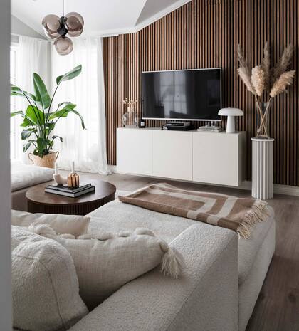 Lámpara colgante (Ljustema). Aunque se trate de un espacio secundario, no faltan plantas ni se renunció a incorporar objetos decorativos, de modo tal de conseguir que la sala de TV resulte tan acogedora como el living.